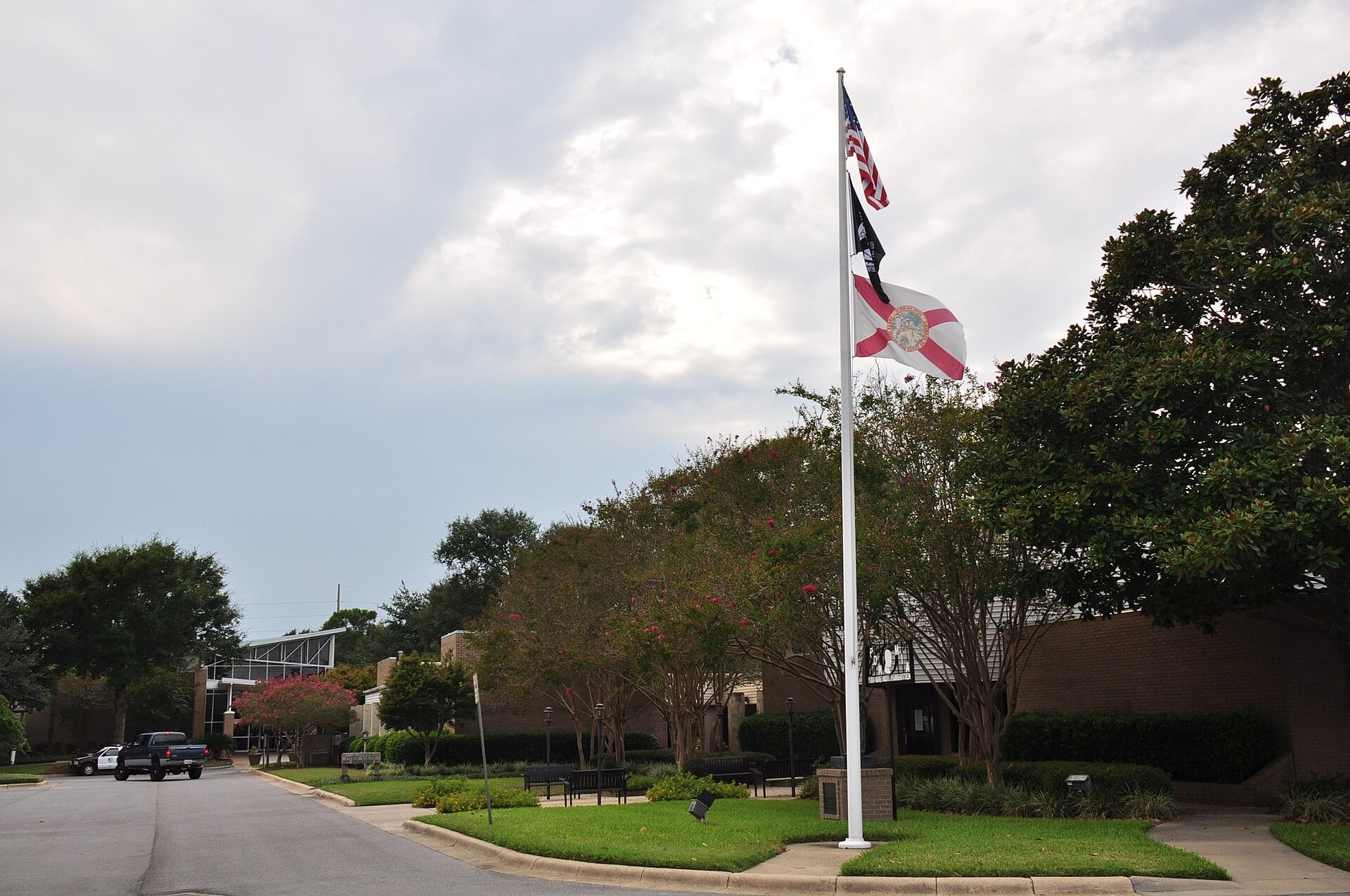 Flags outside Niceville City Hall on a tree-lined street