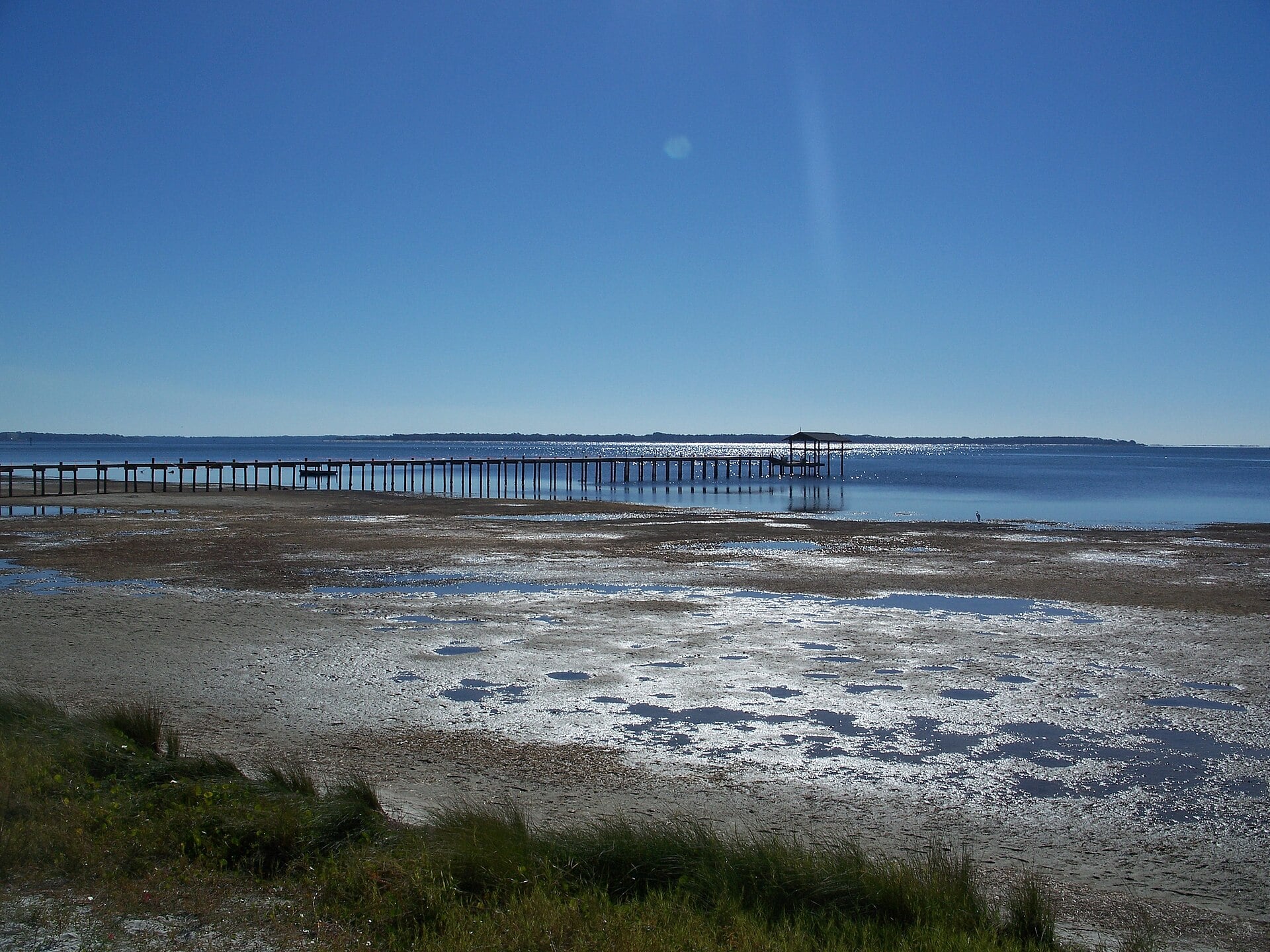 Low tide on St. Andrews Bay in Panama City, with a pier in the distance