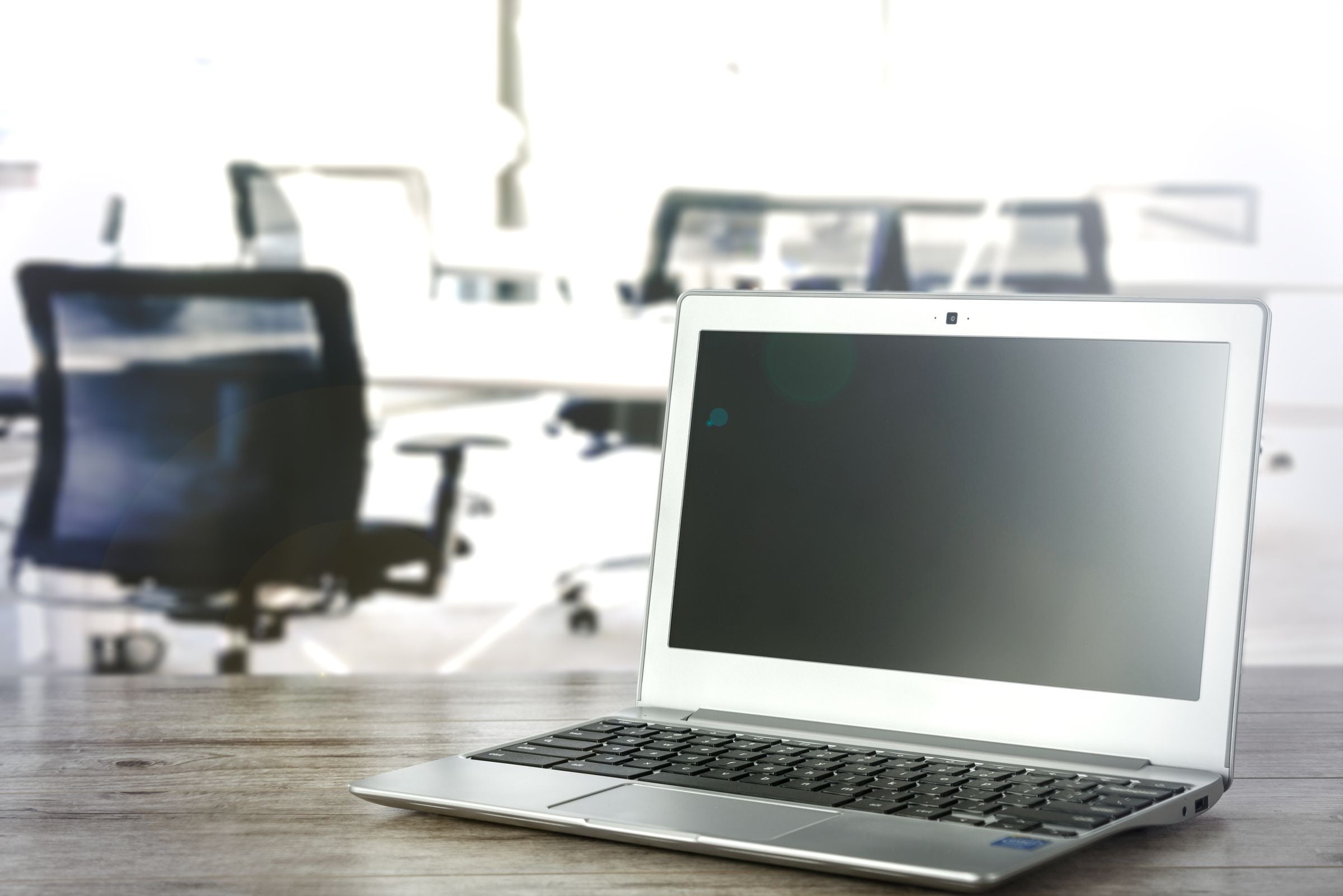 A laptop on a desk in a bright, modern office