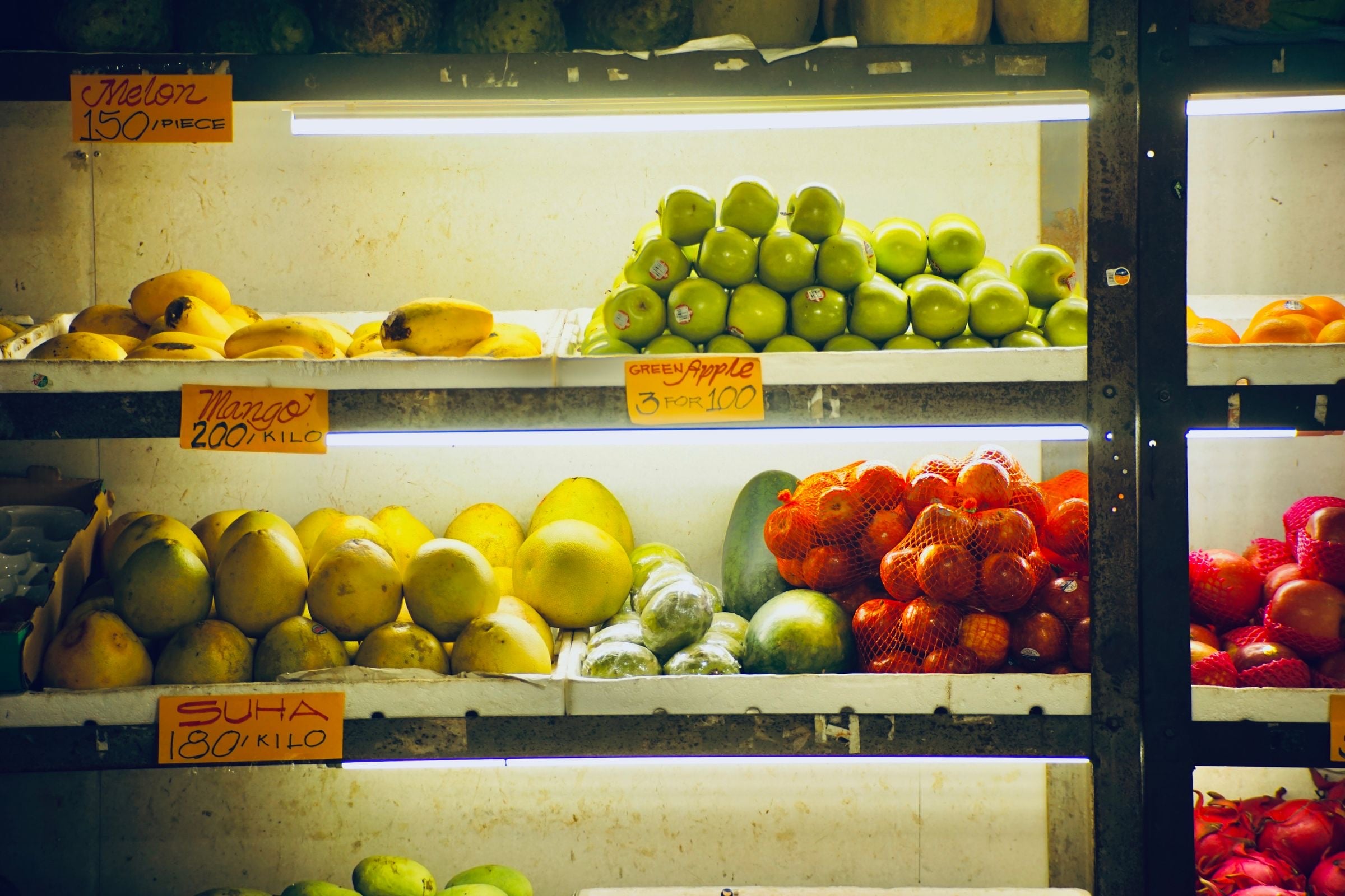 Fruit and vegetables neatly stocked on bright grocery store shelves