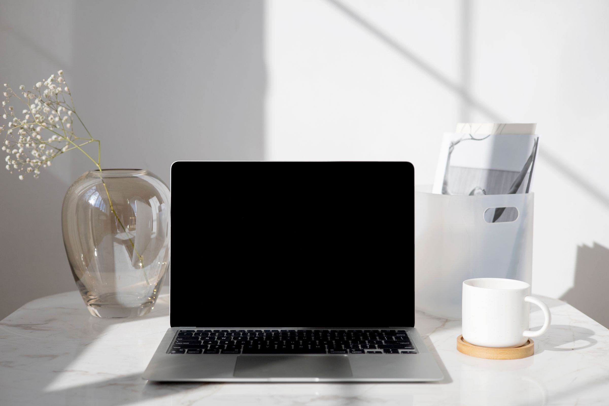A clean, modern desk with a laptop and a coffee cup