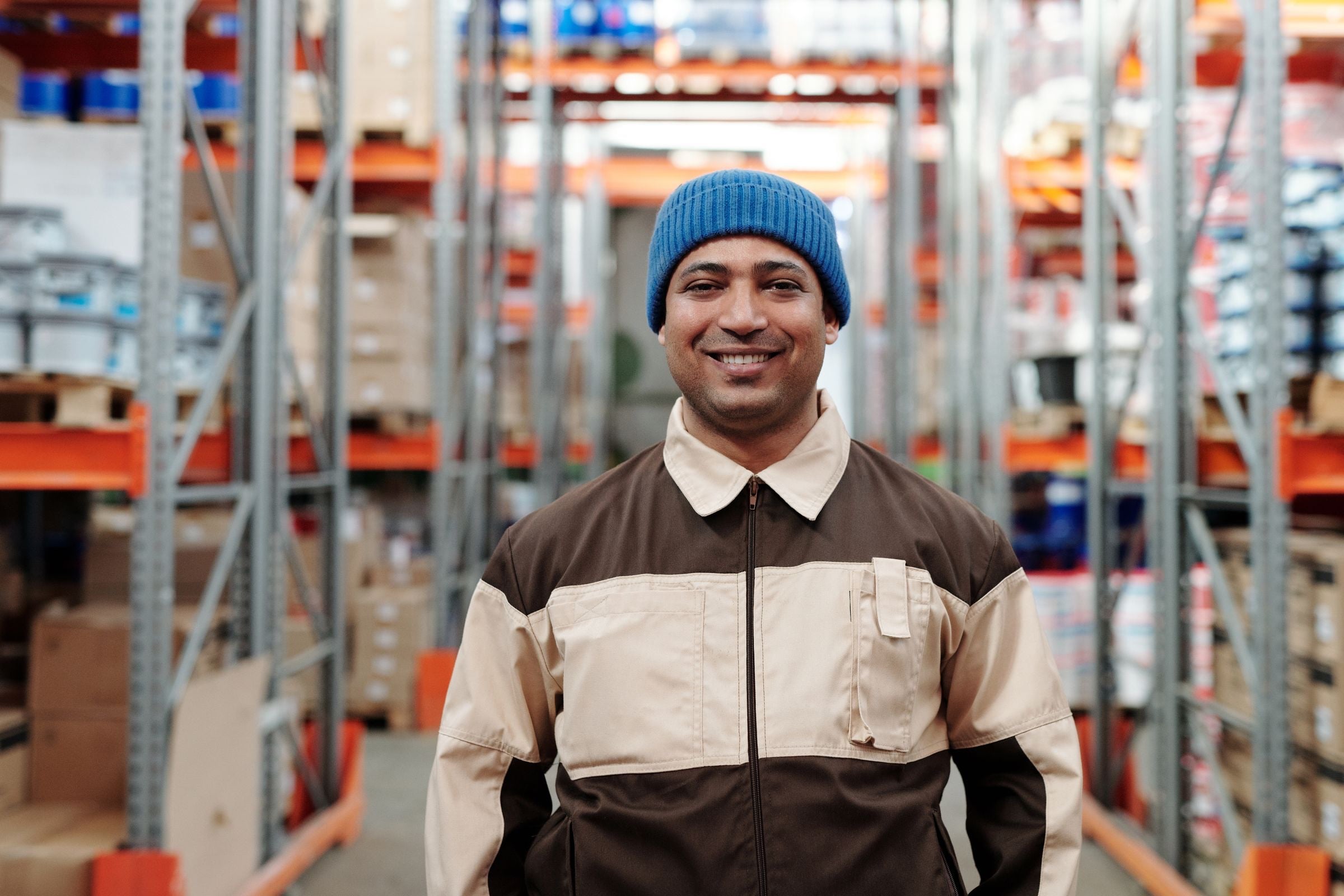 A cheerful warehouse associate among storage racks