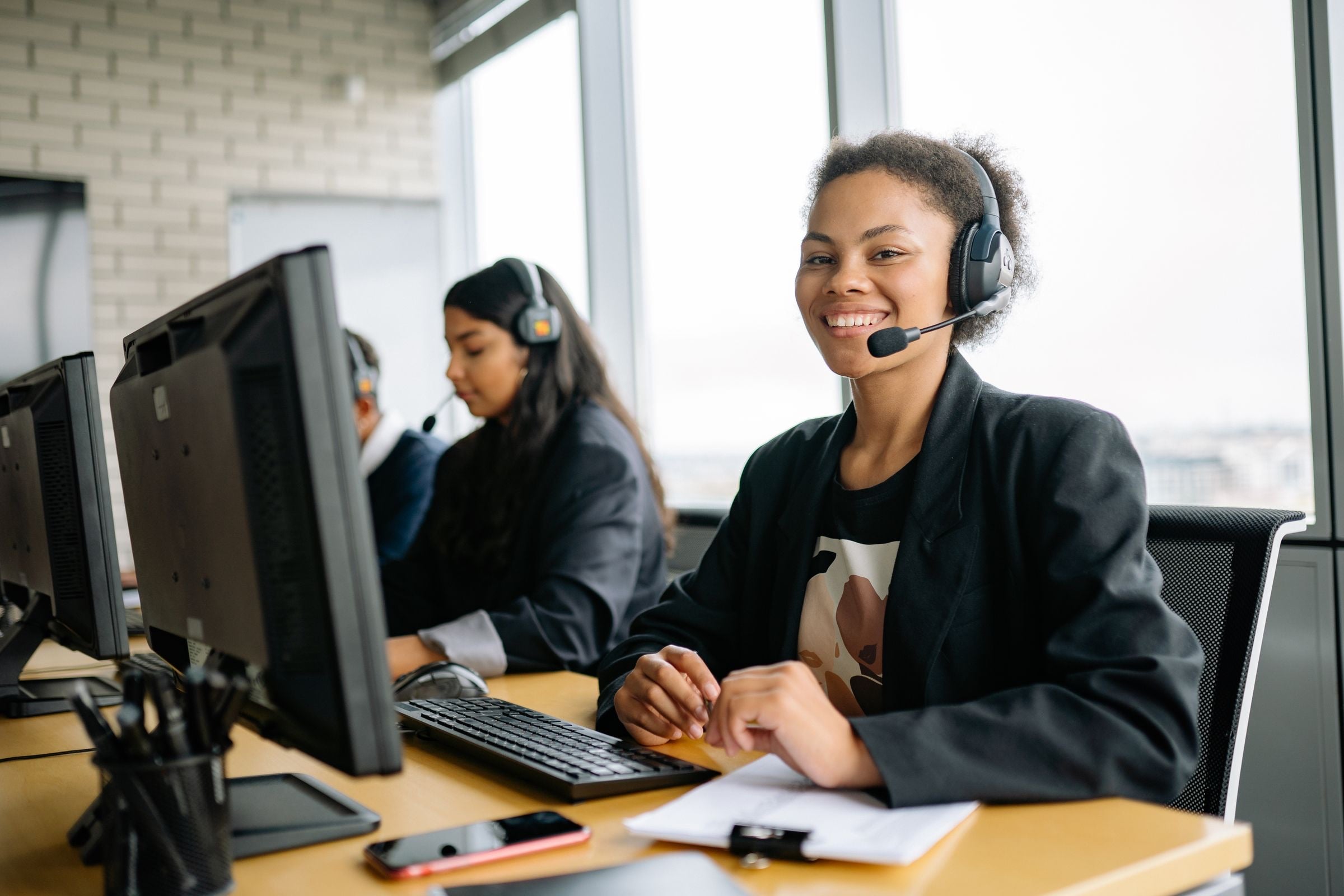Customer service representatives with headsets at their desks
